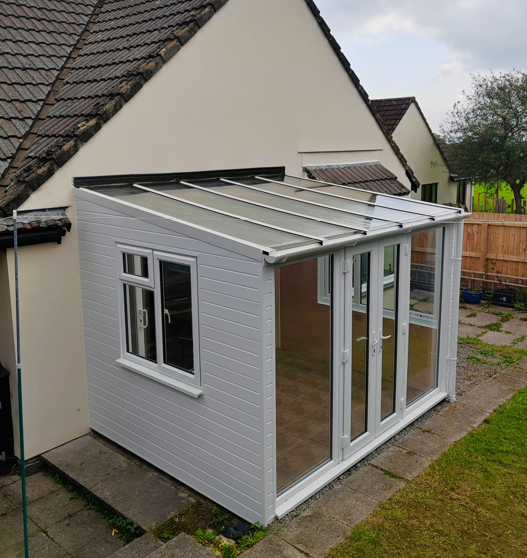 Sunroom project after: side view of the finished UPVC sunroom with cladded panel and glazed roof