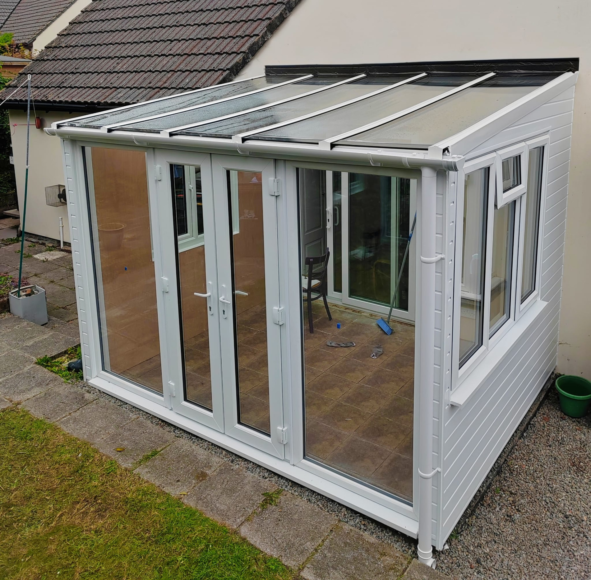 Sunroom project after: new white UPVC lean-to sunroom with glazed roof and French doors