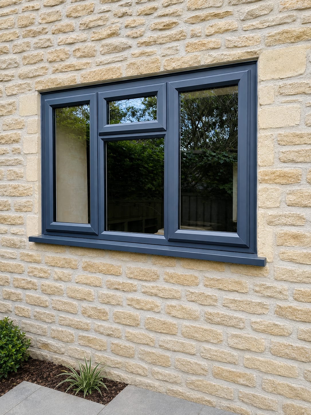 Anthracite grey UPVC casement window with top opener in Cotswold stone