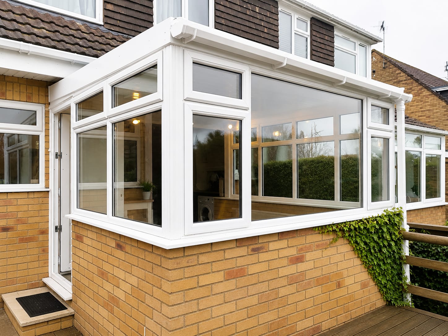 Conservatory project: completed white UPVC conservatory with dwarf brick wall and glazed roof