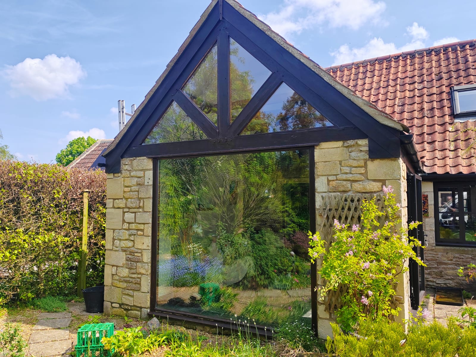 Bespoke black framed glazed gable extension on a Cotswold stone cottage