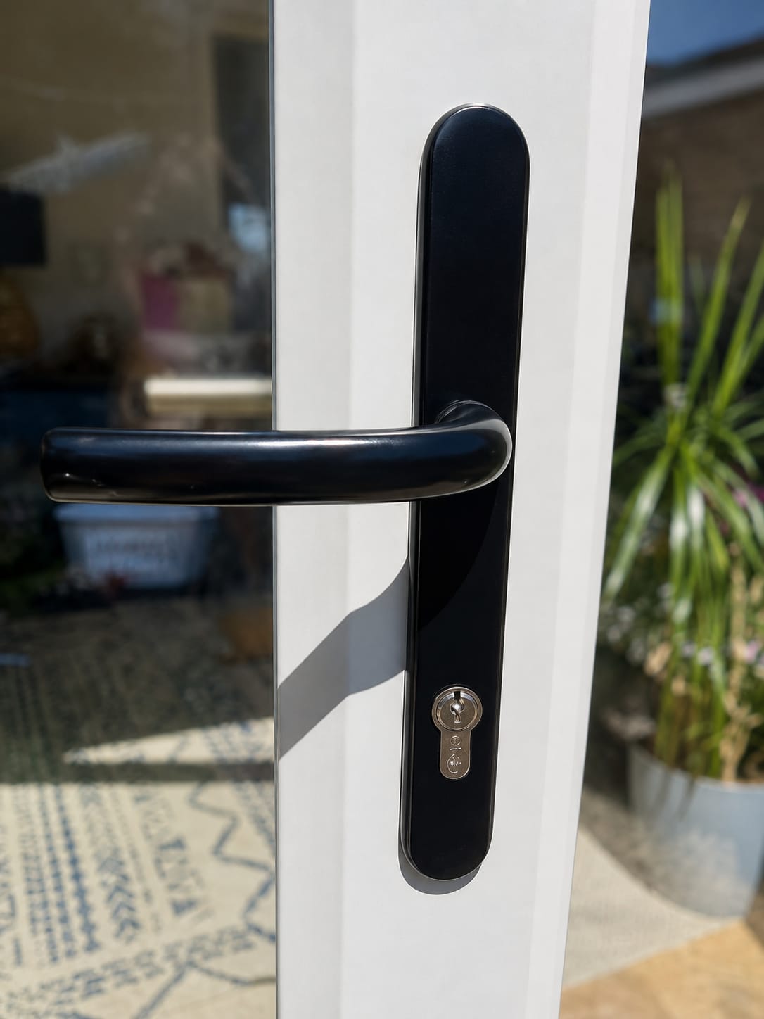 New black multipoint door handle and lock cylinder fitted to a white UPVC door
